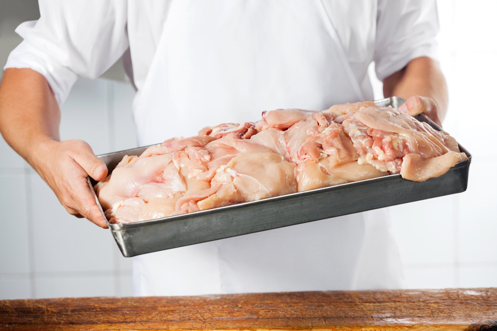 Butcher Carrying Tray Filled with Chicken Pieces